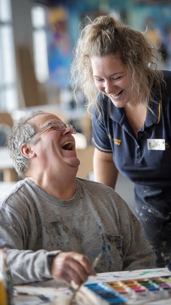 Participant laughing during an art activity with support worker
