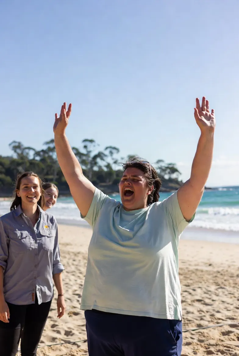 Participant with arms raised at the beach