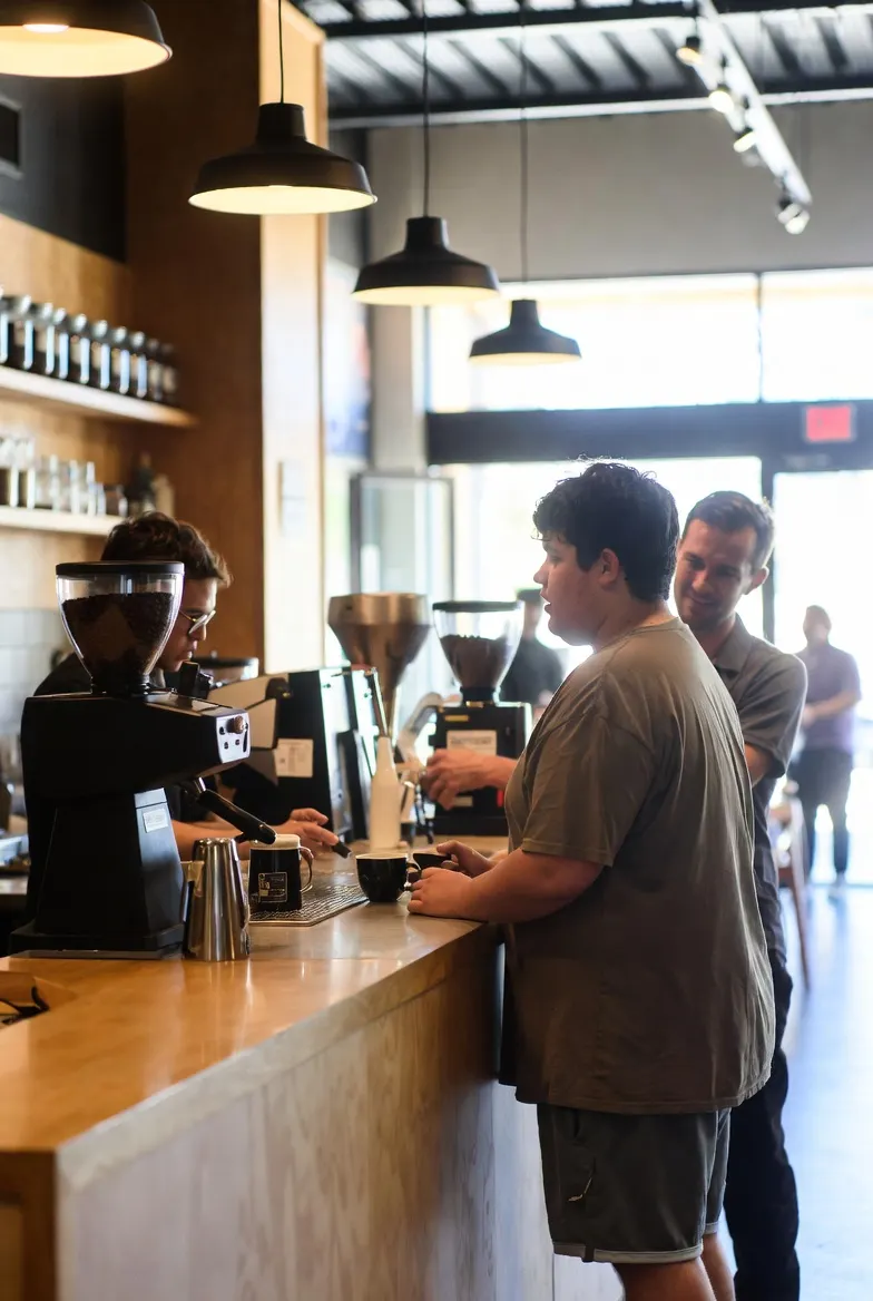 Participant and support worker sharing a coffee