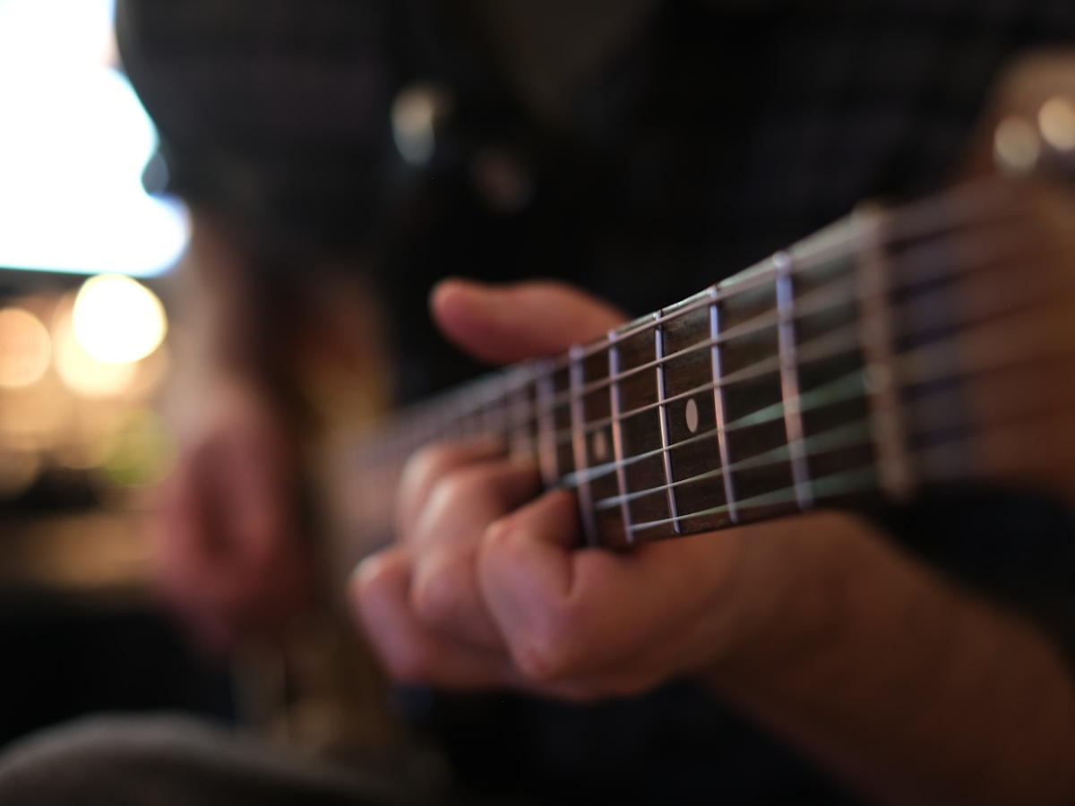 Close-up of hands finding a chord on a guitar